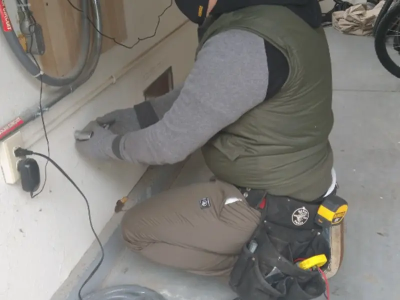 Electrician performing outlet wiring in a Independent Hill garage